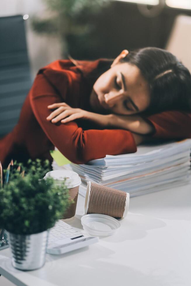 The business lady and the employee take a nap while working on the office desk. Working women are exhausted and sleeping on the table photo