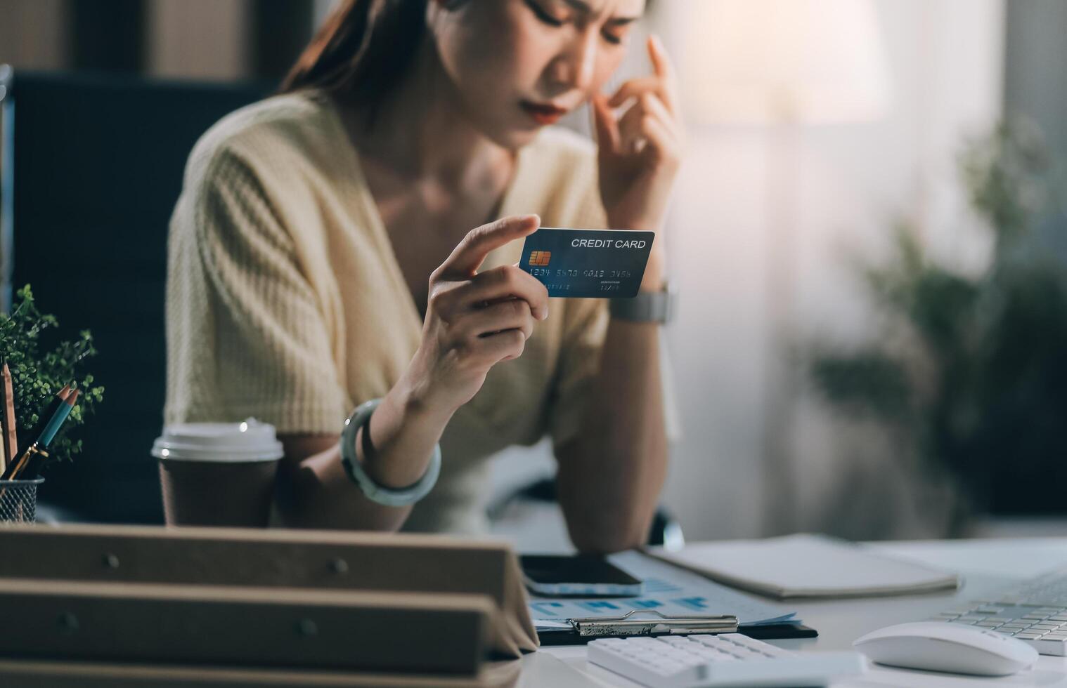 Unhappy and dissatisfied young Asian female office employee contacts a credit card call-center service to inform them of the problems. photo