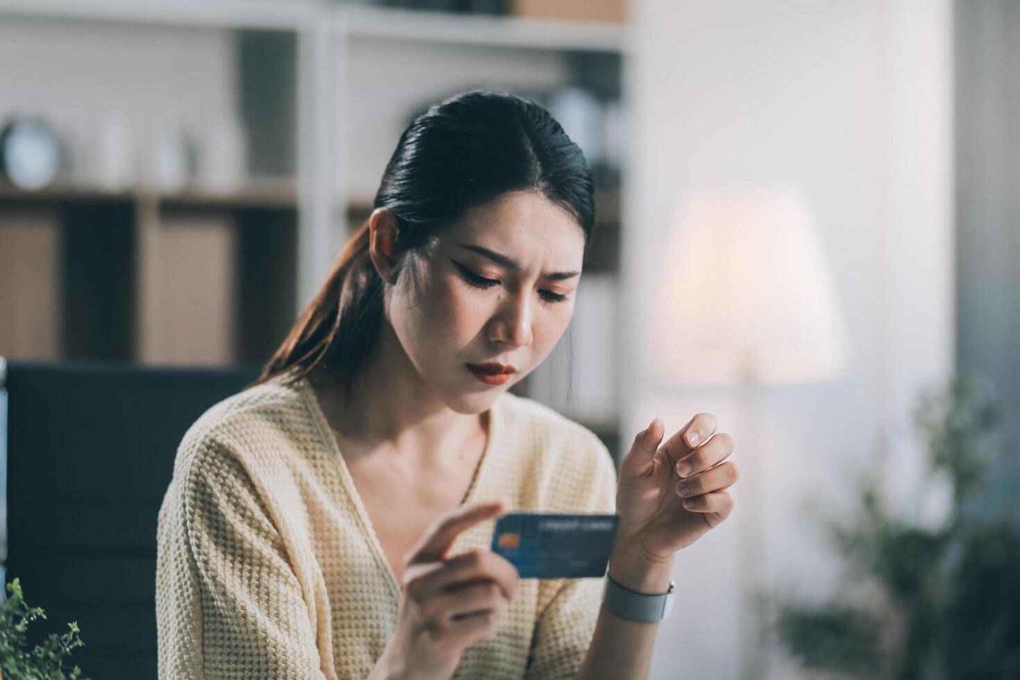 Unhappy and dissatisfied young Asian female office employee contacts a credit card call-center service to inform them of the problems. photo