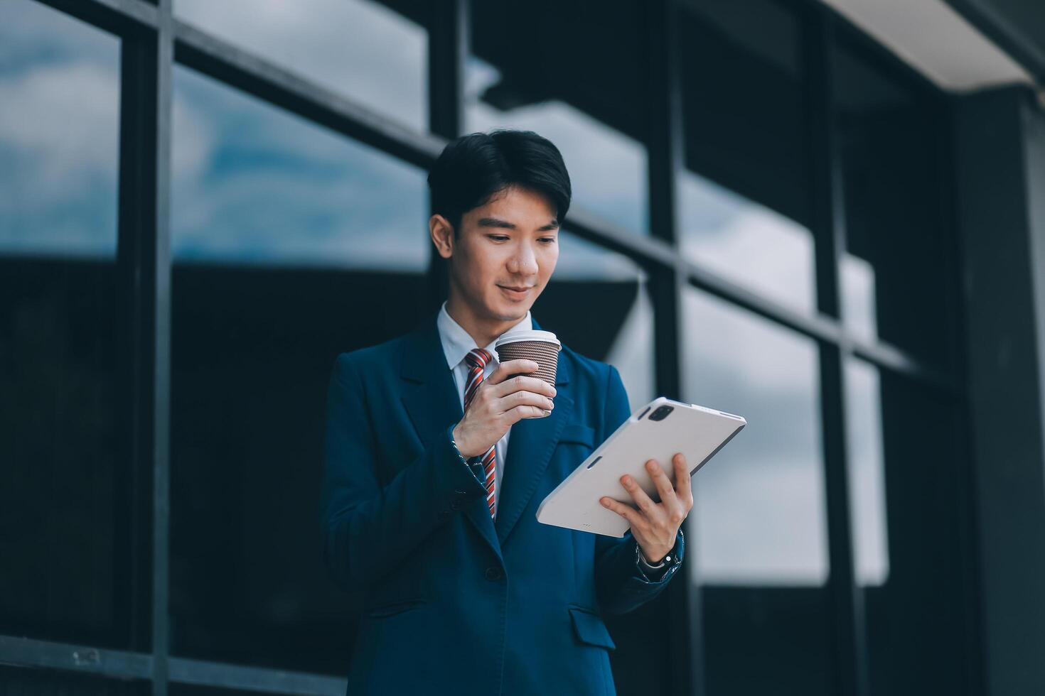 Businessman using tablet and enjoying in coffee break in front of the the corporation. Business, lifestyle concept photo