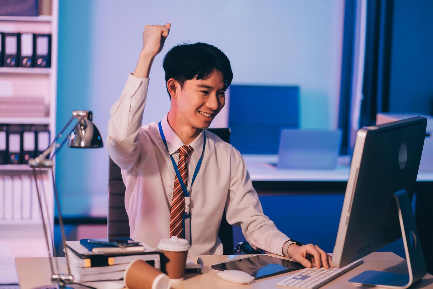 Asian business man standing in office using smartphone at night case accomplished photo
