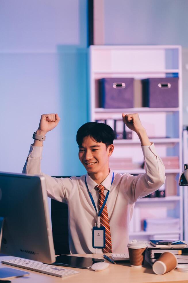 Asian business man standing in office using smartphone at night case accomplished photo