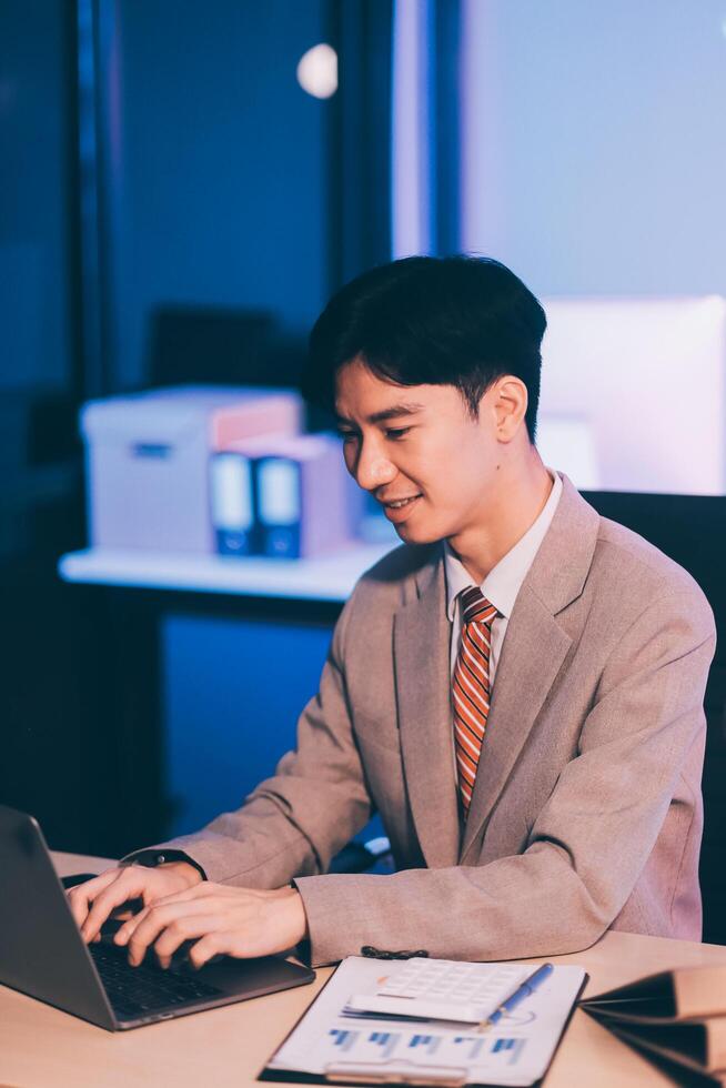 Modern young man working remotely from home at night. photo