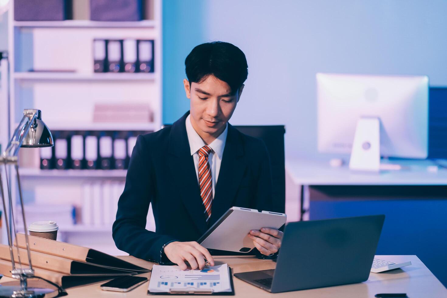 Modern young man working remotely from home at night. photo