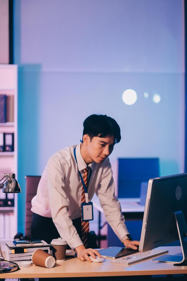 Asian business man standing in office using smartphone at night case accomplished photo