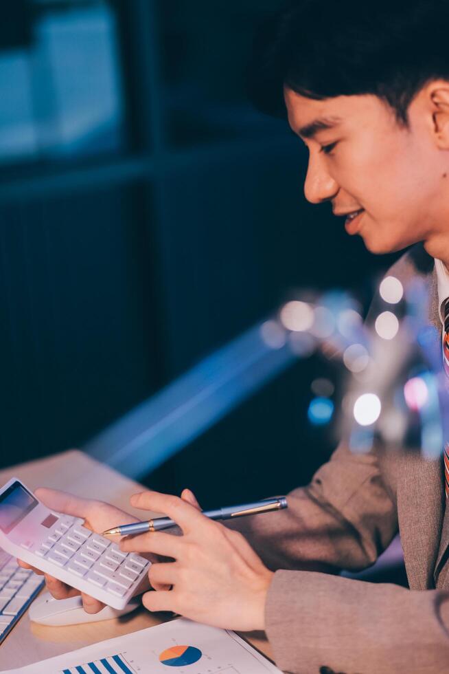 Business accounting concept Businessman uses calculator with laptop computer Budget and borrowed paper Calculate expenses, expenses, taxes online, manage company budgets, close-up images photo