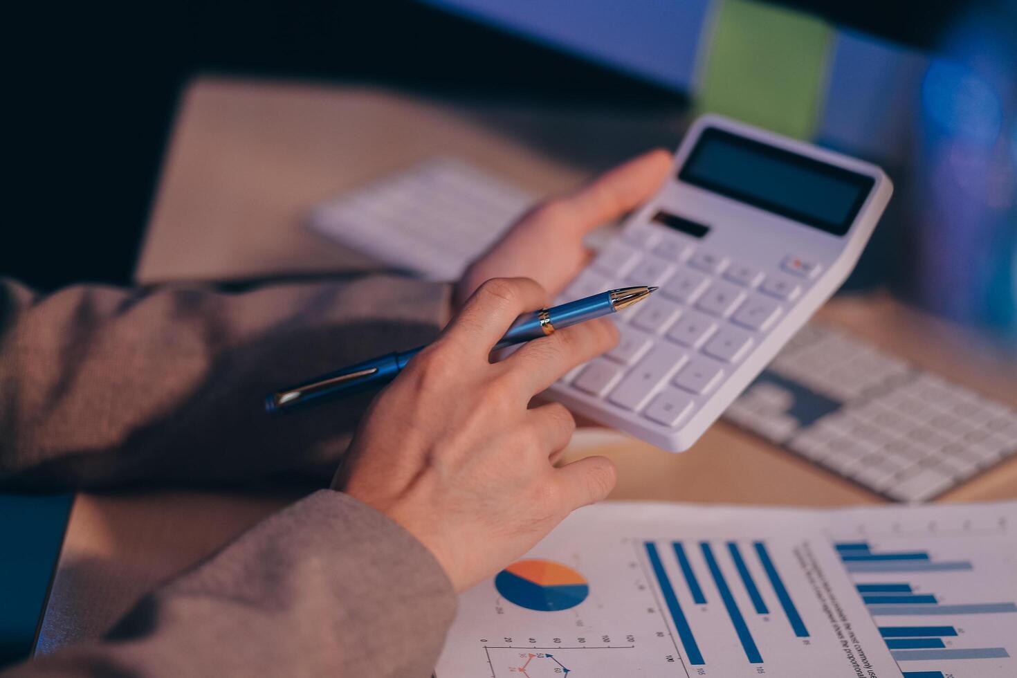 Business accounting concept Businessman uses calculator with laptop computer Budget and borrowed paper Calculate expenses, expenses, taxes online, manage company budgets, close-up images photo