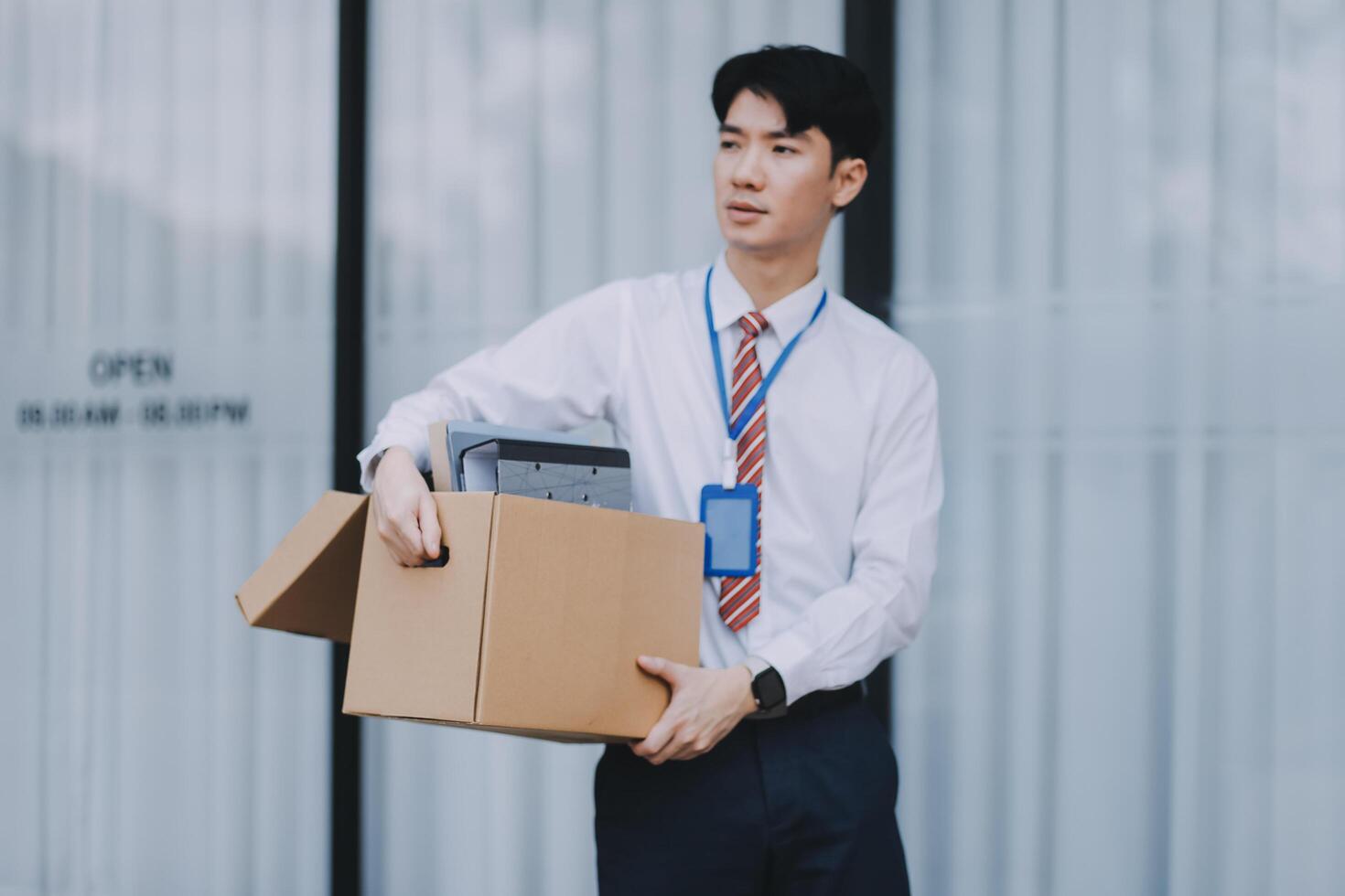 Sadness depressed Businessman with box cardboard packing personal items after losing jobs. Failure businessman sitting at stair front of building. Your fired Unemployed Jobless People Crisis photo