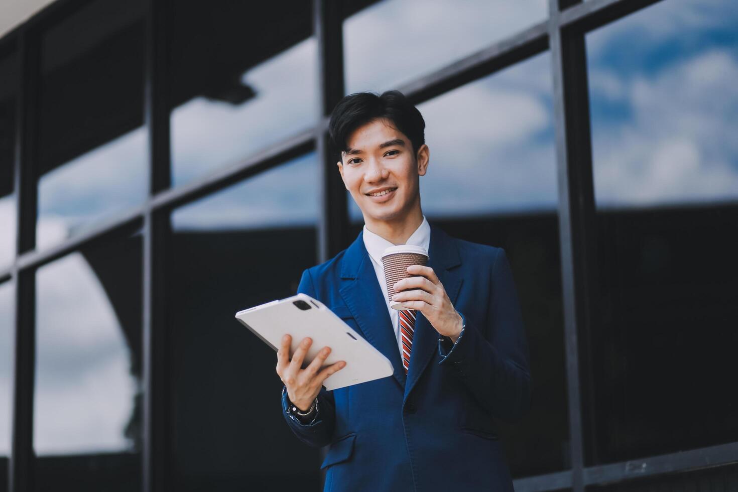 Businessman using tablet and enjoying in coffee break in front of the the corporation. Business, lifestyle concept photo