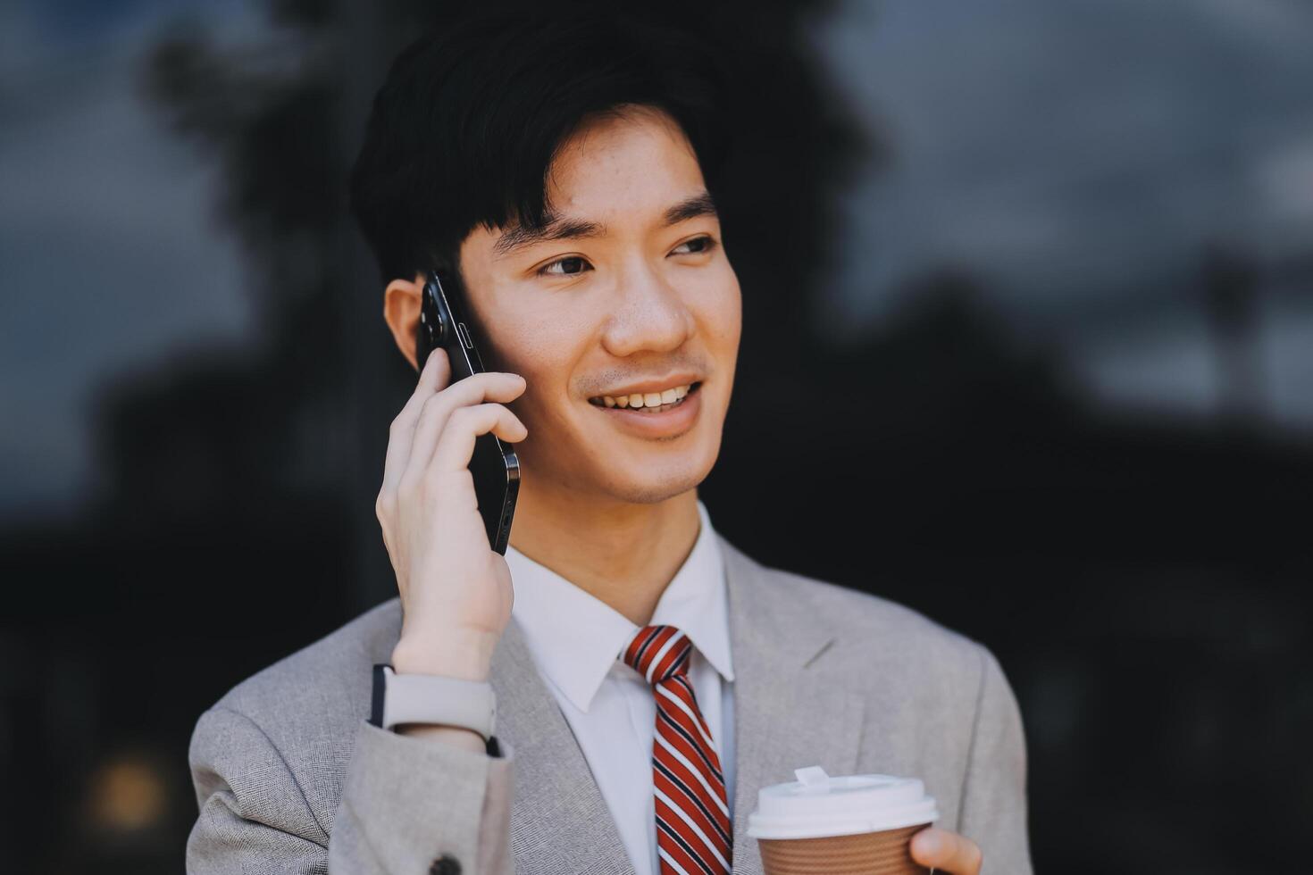 Good news about project. Young businessman talking with client via mobile phone and checking money transfer on tablet. Business, education, lifestyle concept photo