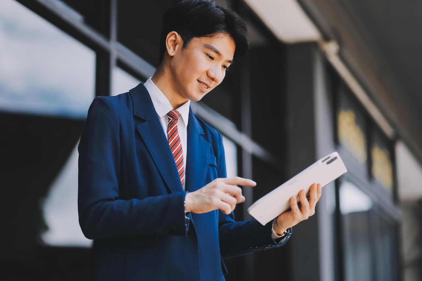 Businessman using tablet and enjoying in coffee break in front of the the corporation. Business, lifestyle concept photo