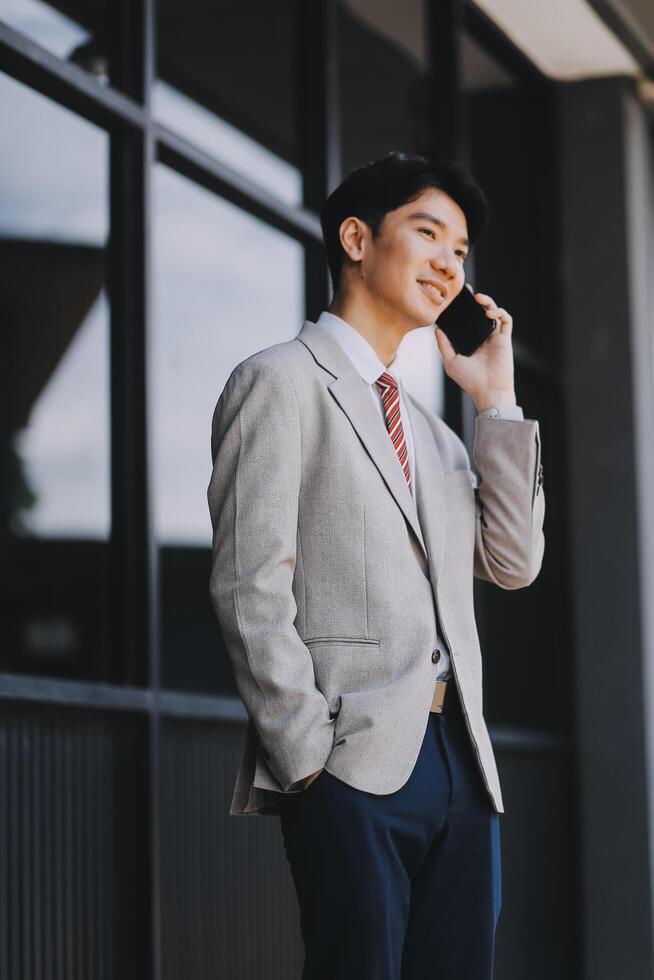 Good news about project. Young businessman talking with client via mobile phone and checking money transfer on tablet. Business, education, lifestyle concept photo