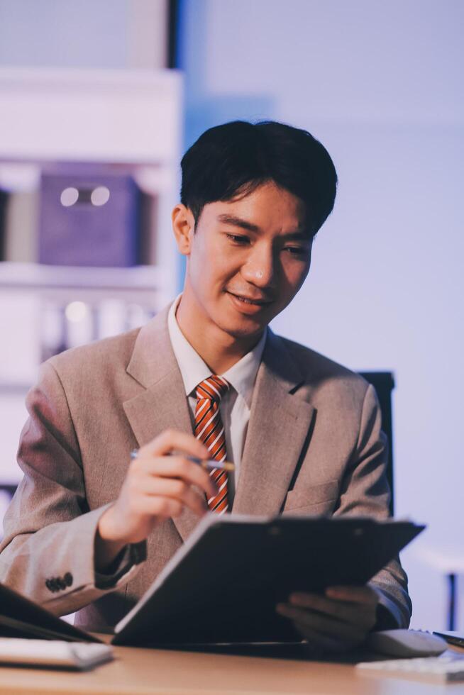 Businessman working hard overtime at night at the office. He felt tired and stressed from work. photo