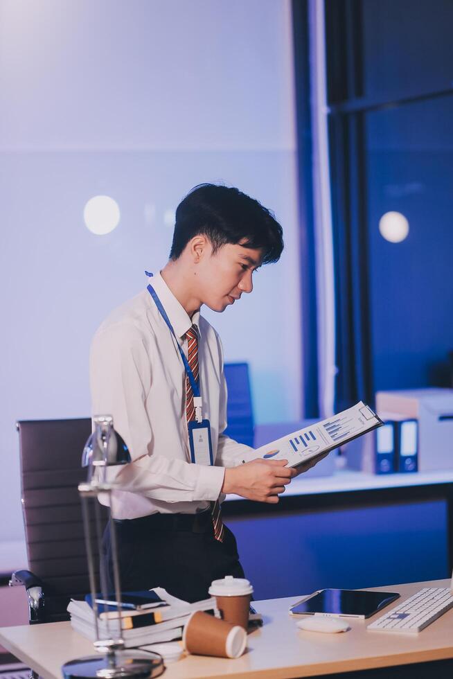 Businessman working hard overtime at night at the office. He felt tired and stressed from work. photo