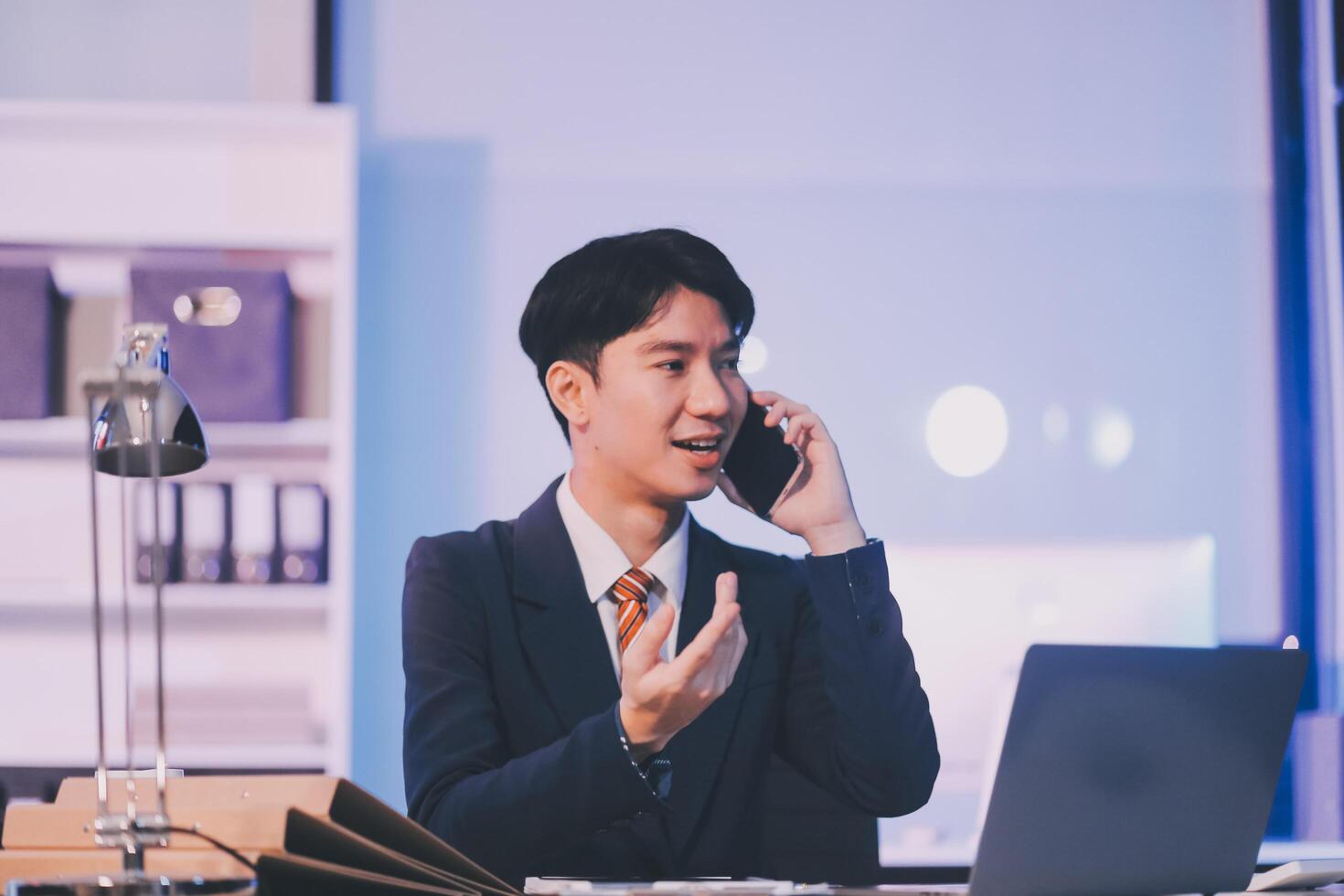 Serious trader using mobile phone app on smartphone for checking stock trading data analysis concept, focused businessman holding cellphone working in office with financial graph on computer monitors photo