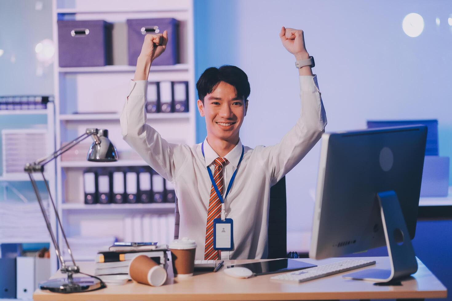 Asian business man standing in office using smartphone at night case accomplished photo