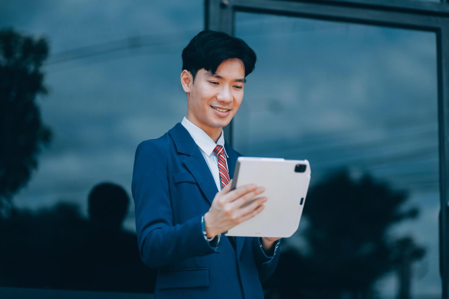 Businessman using tablet and enjoying in coffee break in front of the the corporation. Business, lifestyle concept photo