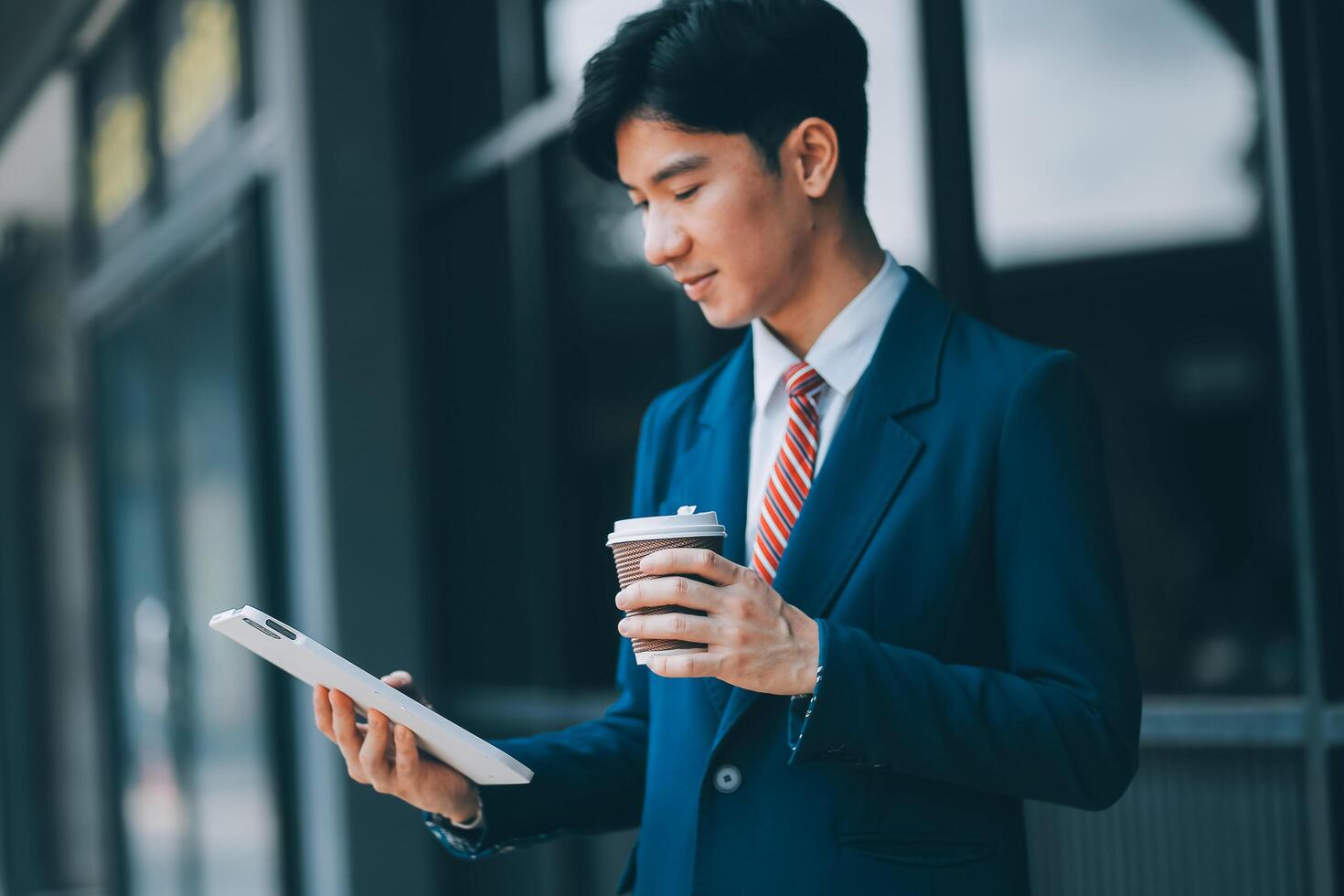 Businessman using tablet and enjoying in coffee break in front of the the corporation. Business, lifestyle concept photo