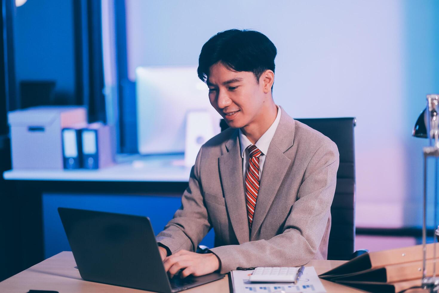 Modern young man working remotely from home at night. photo
