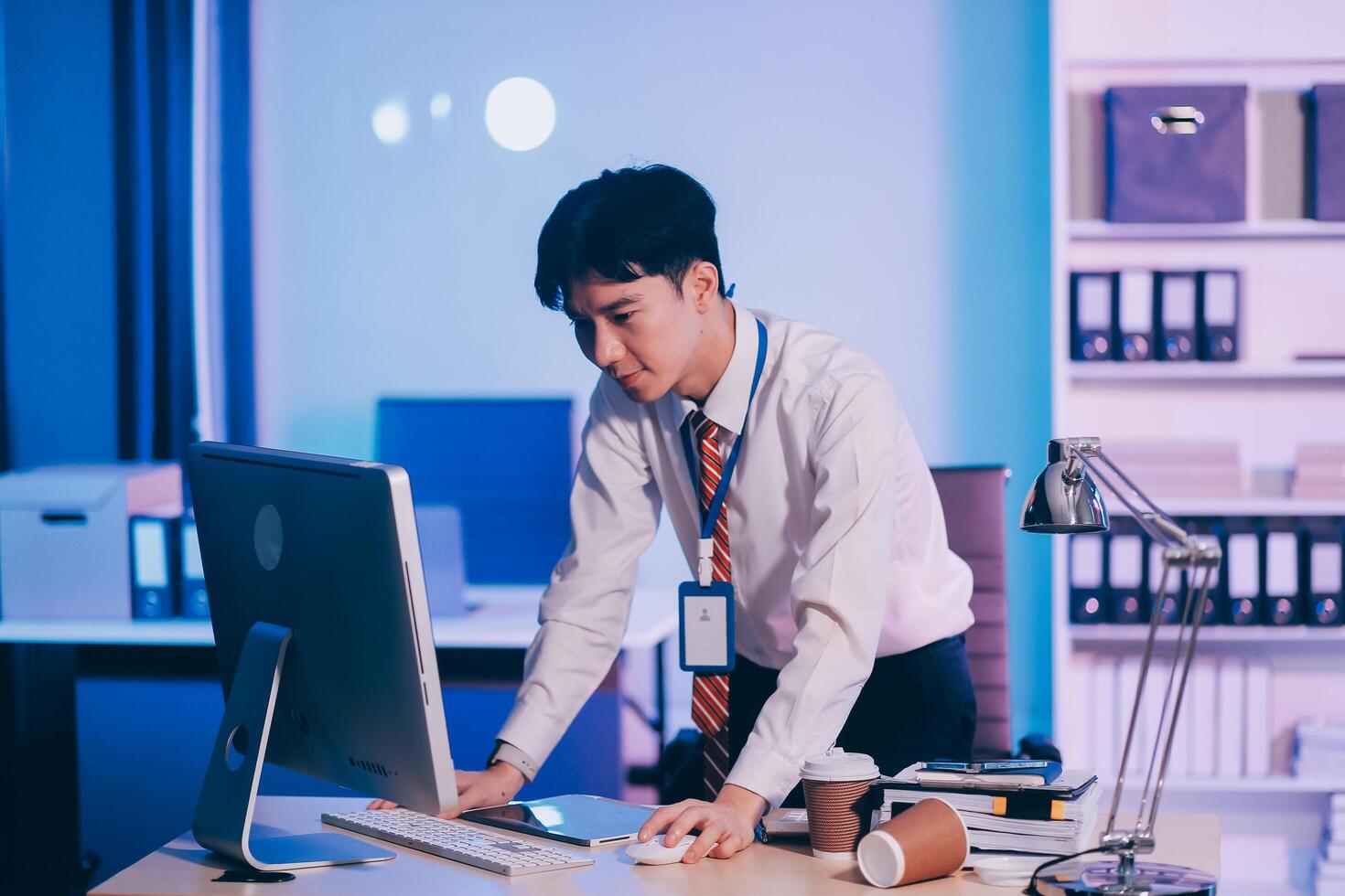 Asian business man standing in office using smartphone at night case accomplished photo