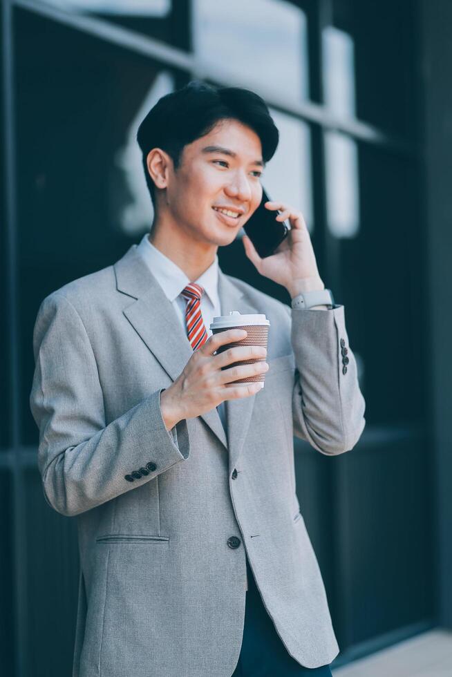 Good news about project. Young businessman talking with client via mobile phone and checking money transfer on tablet. Business, education, lifestyle concept photo