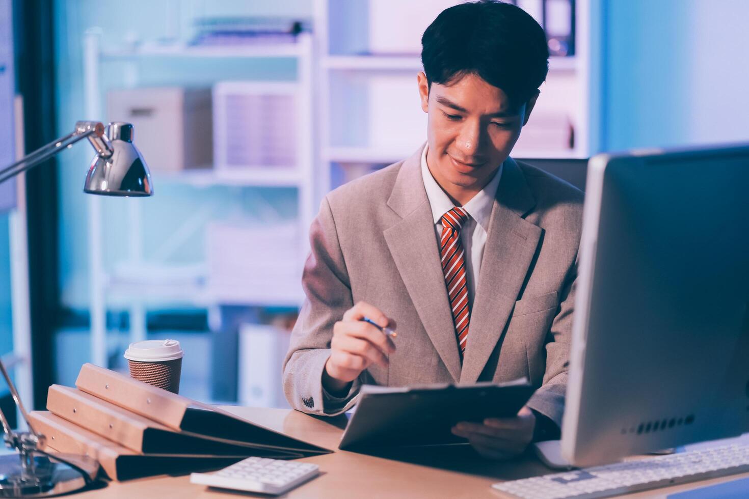 Businessman working hard overtime at night at the office. He felt tired and stressed from work. photo
