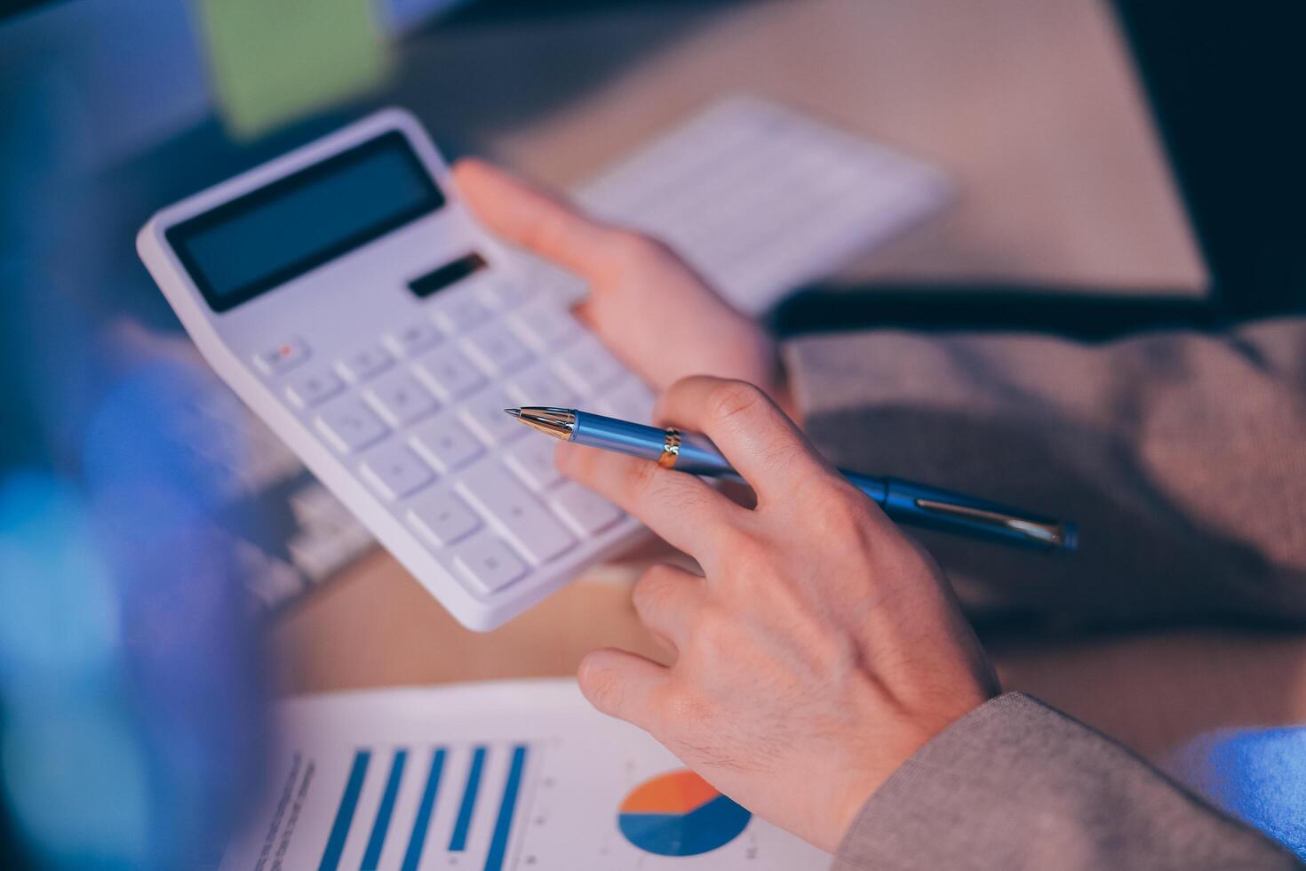 Business accounting concept Businessman uses calculator with laptop computer Budget and borrowed paper Calculate expenses, expenses, taxes online, manage company budgets, close-up images photo
