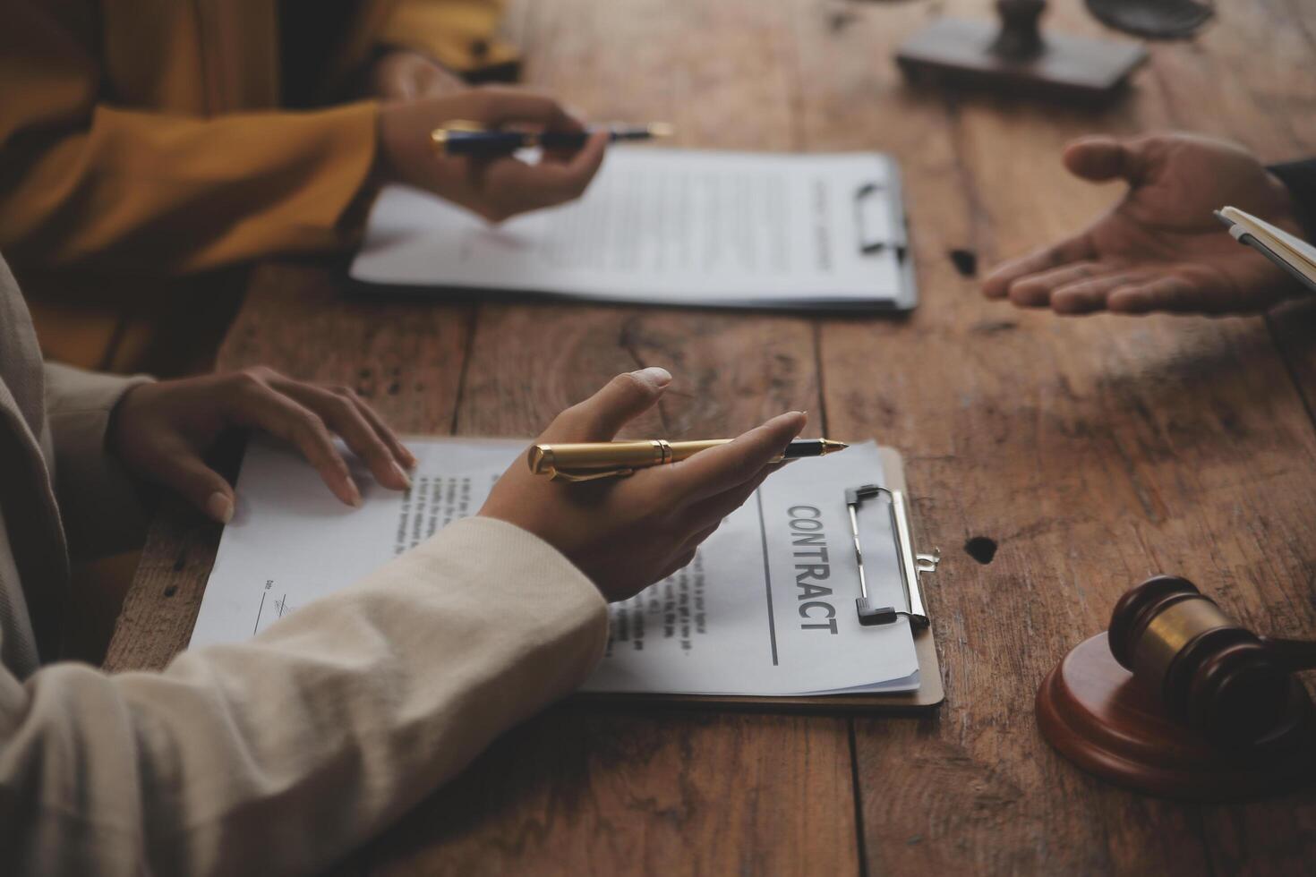 Business and lawyers discussing contract papers with brass scale on desk in office. Law, legal services, advice, justice and law concept picture with film grain effect photo