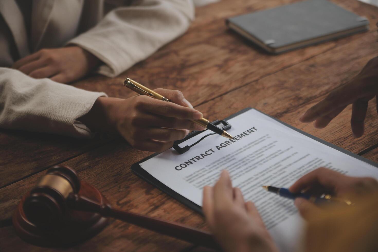 Business and lawyers discussing contract papers with brass scale on desk in office. Law, legal services, advice, justice and law concept picture with film grain effect photo