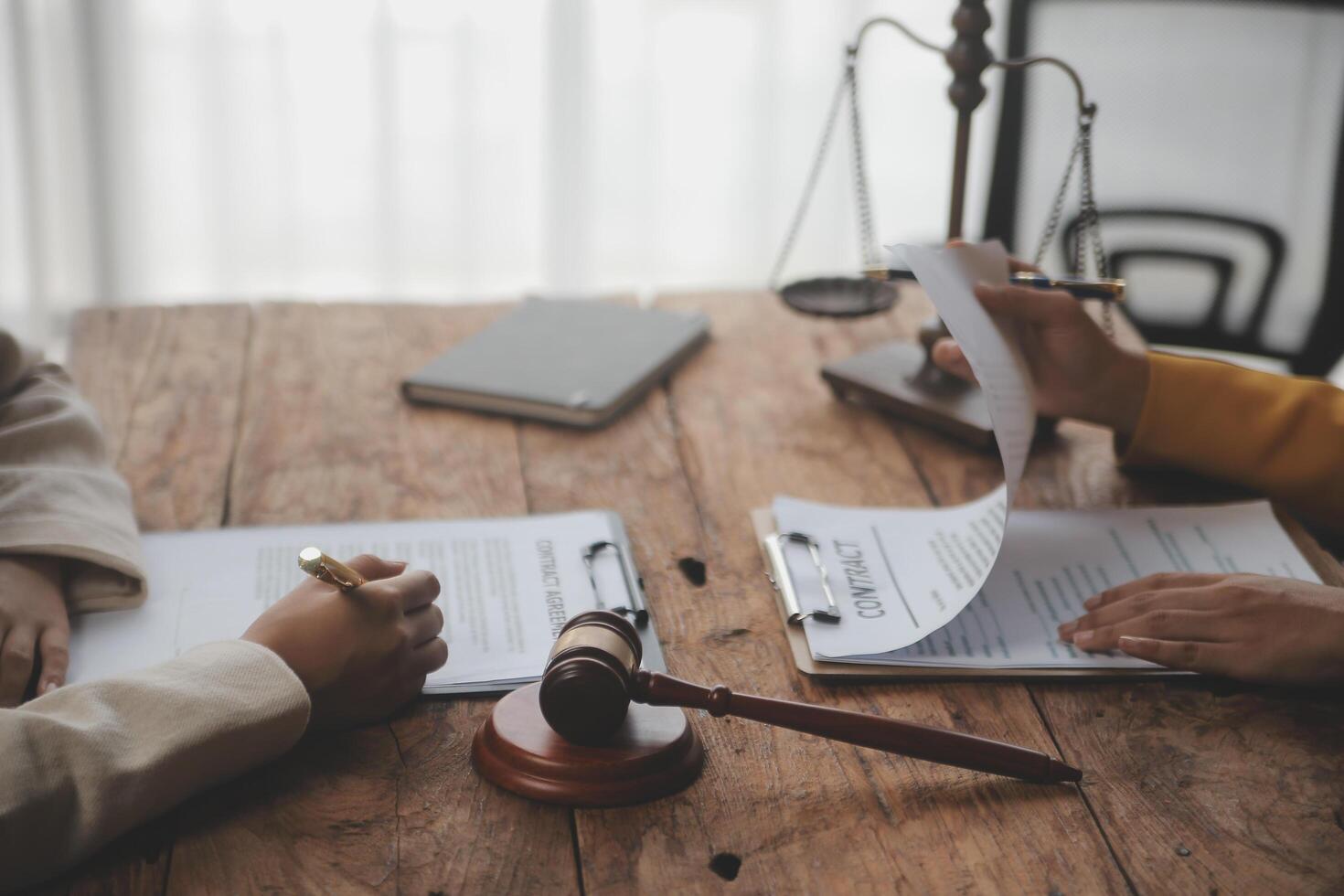Business and lawyers discussing contract papers with brass scale on desk in office. Law, legal services, advice, justice and law concept picture with film grain effect photo