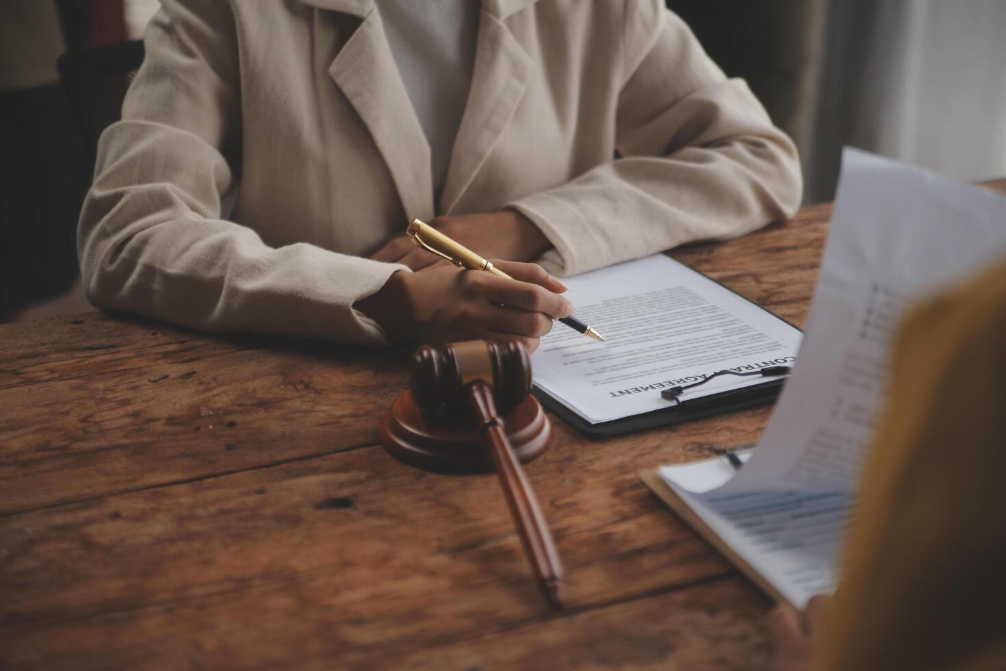 Business and lawyers discussing contract papers with brass scale on desk in office. Law, legal services, advice, justice and law concept picture with film grain effect photo