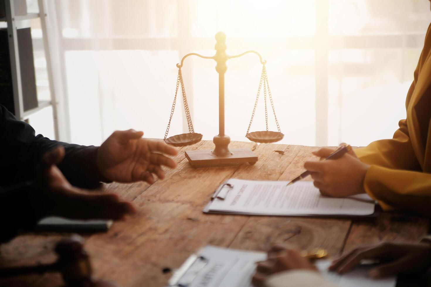 Business and lawyers discussing contract papers with brass scale on desk in office. Law, legal services, advice, justice and law concept picture with film grain effect photo