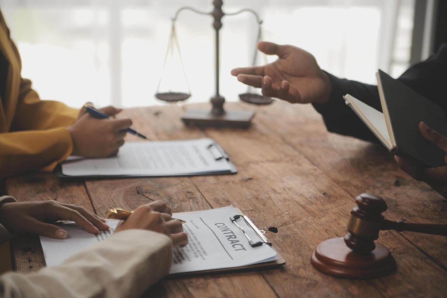Business and lawyers discussing contract papers with brass scale on desk in office. Law, legal services, advice, justice and law concept picture with film grain effect photo
