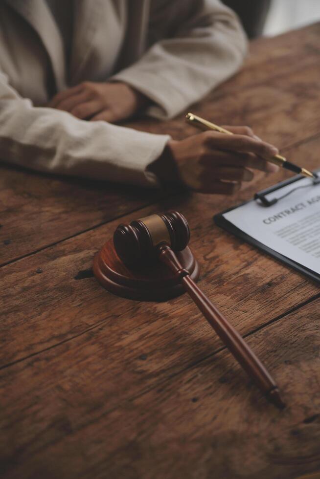 Business and lawyers discussing contract papers with brass scale on desk in office. Law, legal services, advice, justice and law concept picture with film grain effect photo