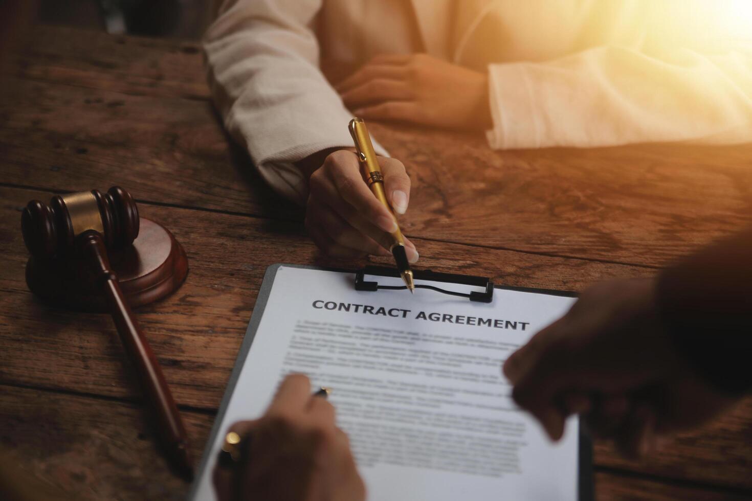 Business and lawyers discussing contract papers with brass scale on desk in office. Law, legal services, advice, justice and law concept picture with film grain effect photo