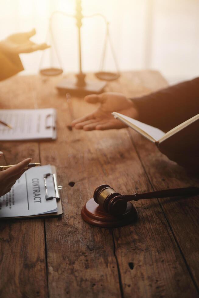 Business and lawyers discussing contract papers with brass scale on desk in office. Law, legal services, advice, justice and law concept picture with film grain effect photo