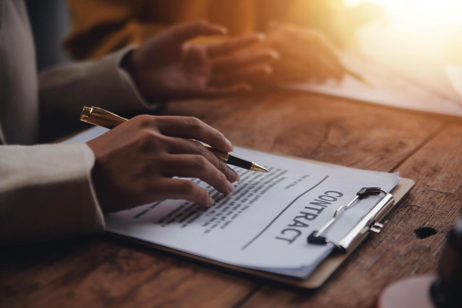 Business and lawyers discussing contract papers with brass scale on desk in office. Law, legal services, advice, justice and law concept picture with film grain effect photo