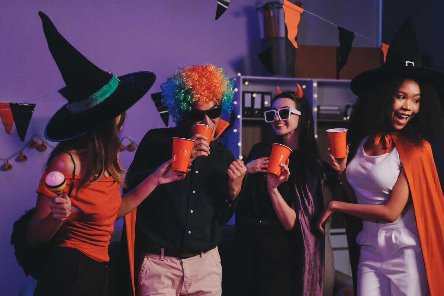Joyful office Halloween party with coworkers in costumes, celebrating with drinks and laughter, fostering teamwork and festive spirit photo