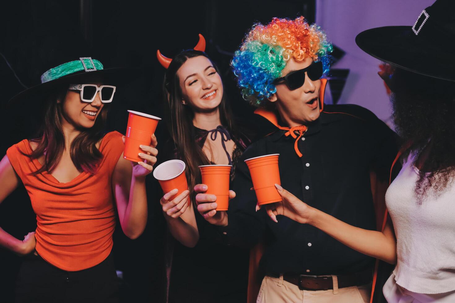 Joyful office Halloween party with coworkers in costumes, celebrating with drinks and laughter, fostering teamwork and festive spirit photo