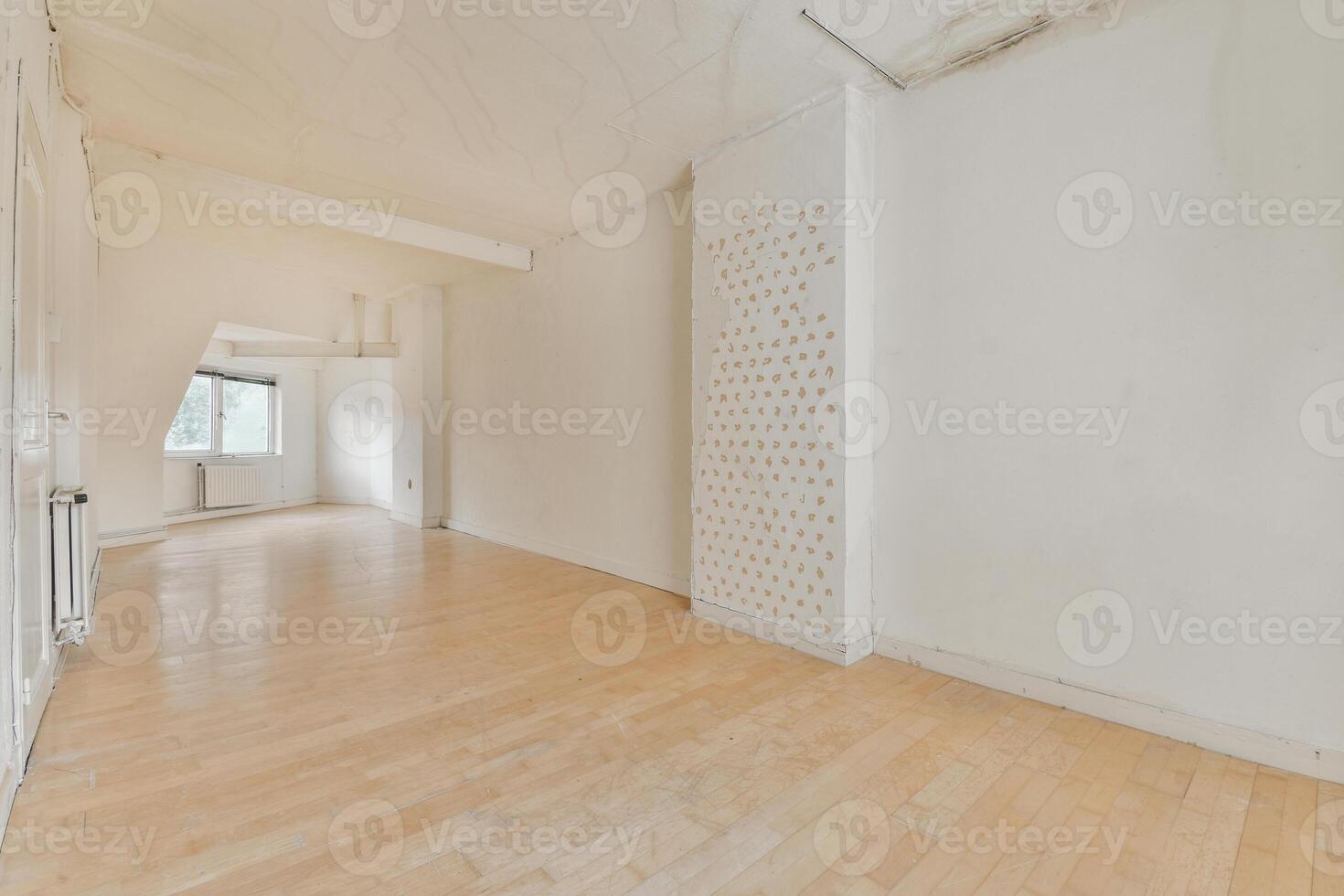 An empty room with wooden floors and white walls photo