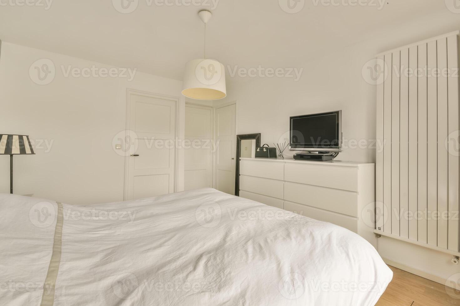 A bedroom with a white bed and a television photo
