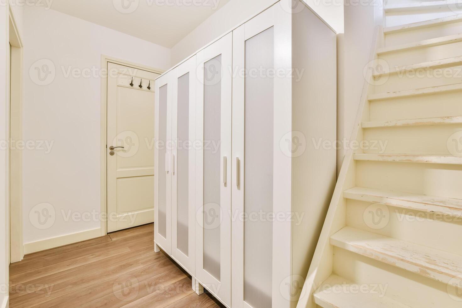 White wardrobe and wooden stairs in a hallway photo