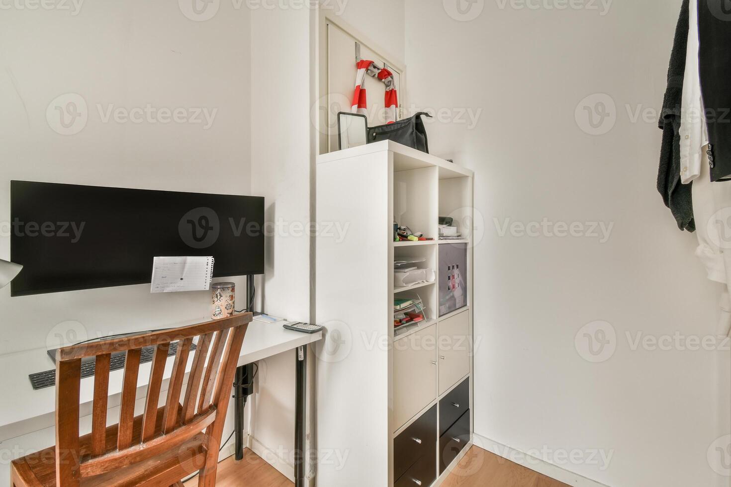 A small room with a desk, chair and computer photo