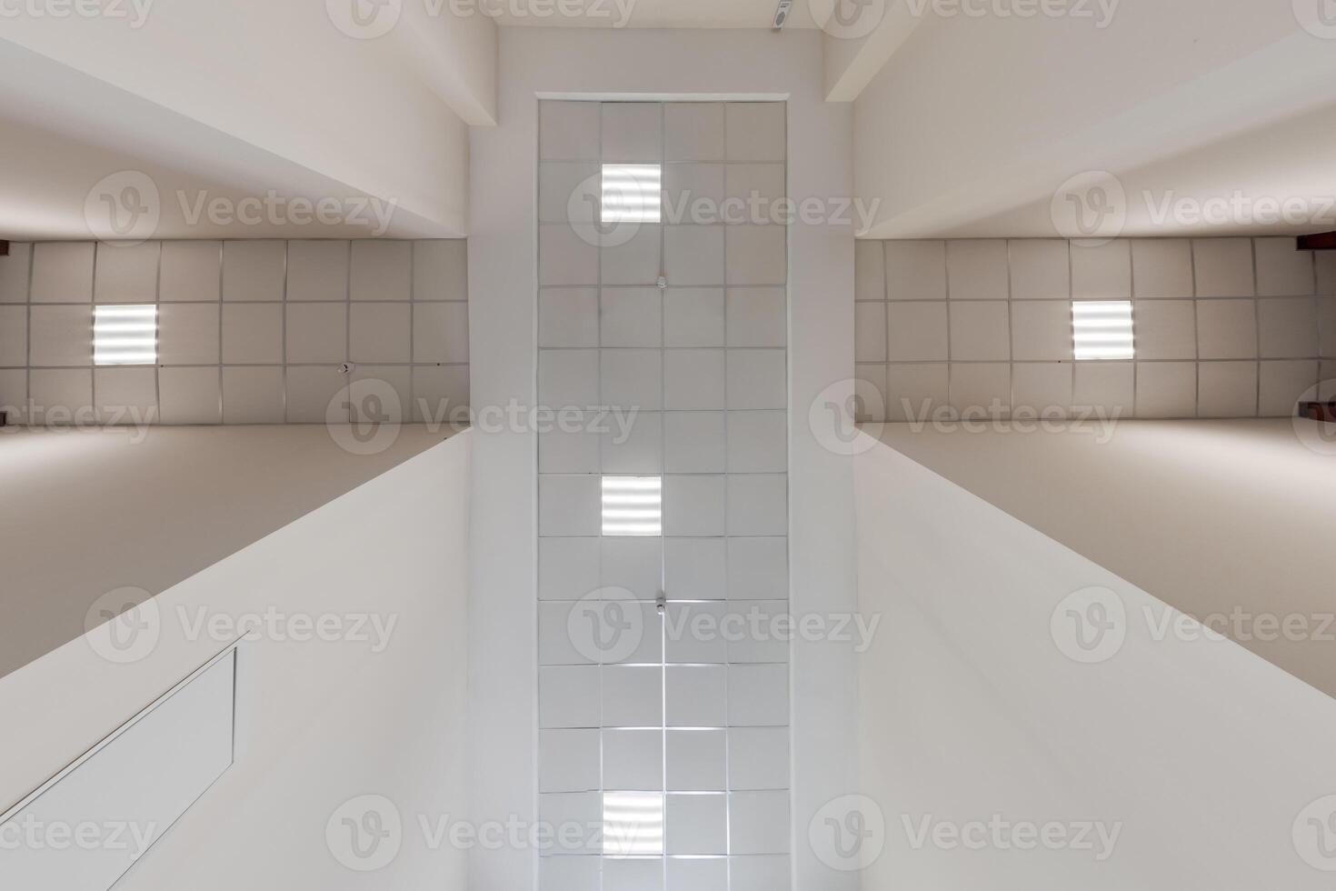 cassette stretched or suspended ceiling with square halogen spots lamps and drywall construction in empty room in house or office. Looking up view photo