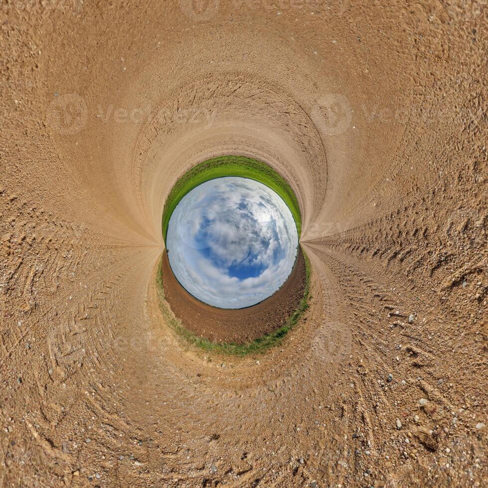 blue hole sphere or globe little planet inside sand or dry ground frame background with tractor tracks photo