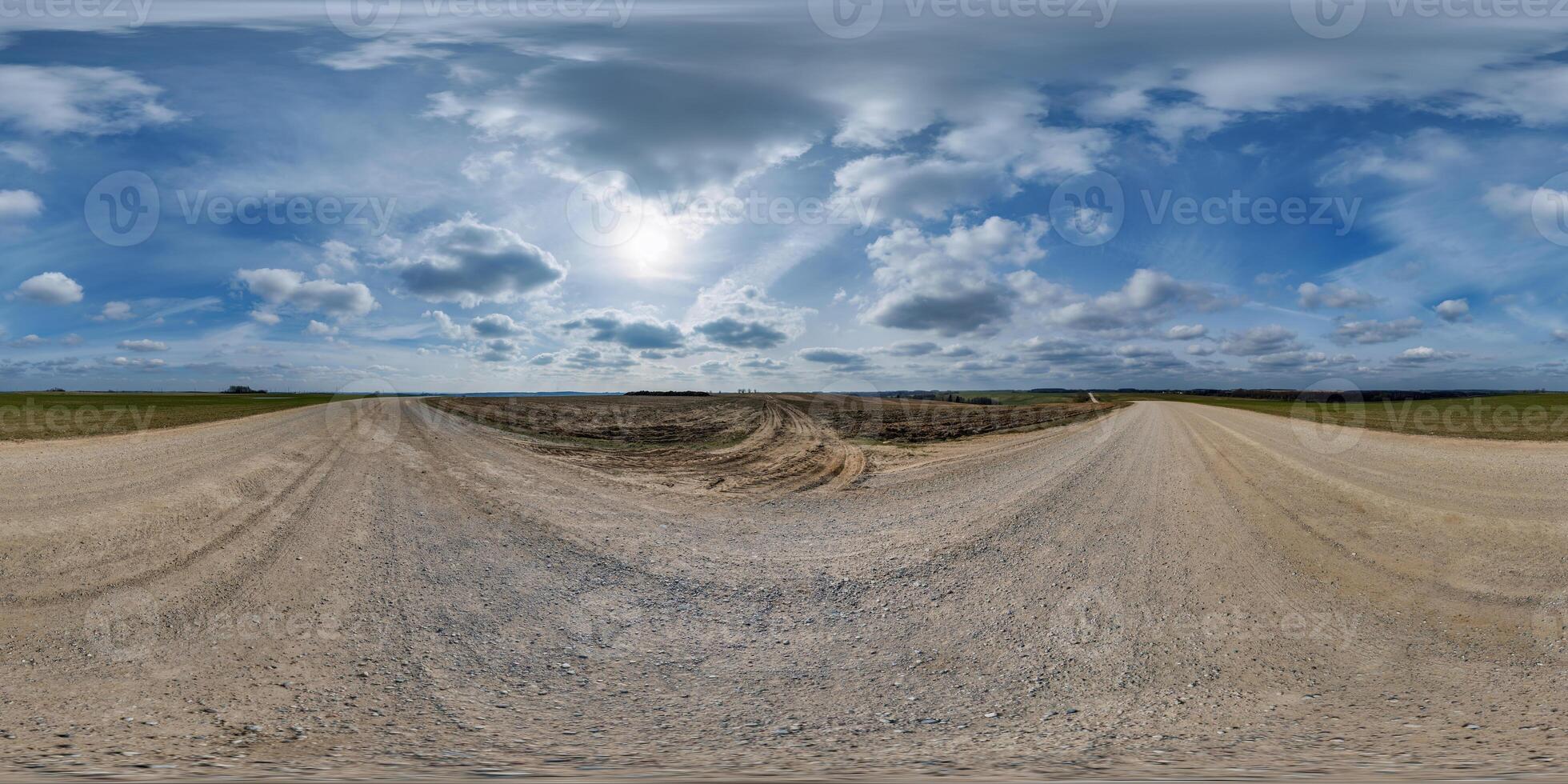 hdri 360 panorama on gravel road among fields in spring nasty evening before sunset in equirectangular full seamless spherical projection, for VR AR virtual reality content photo