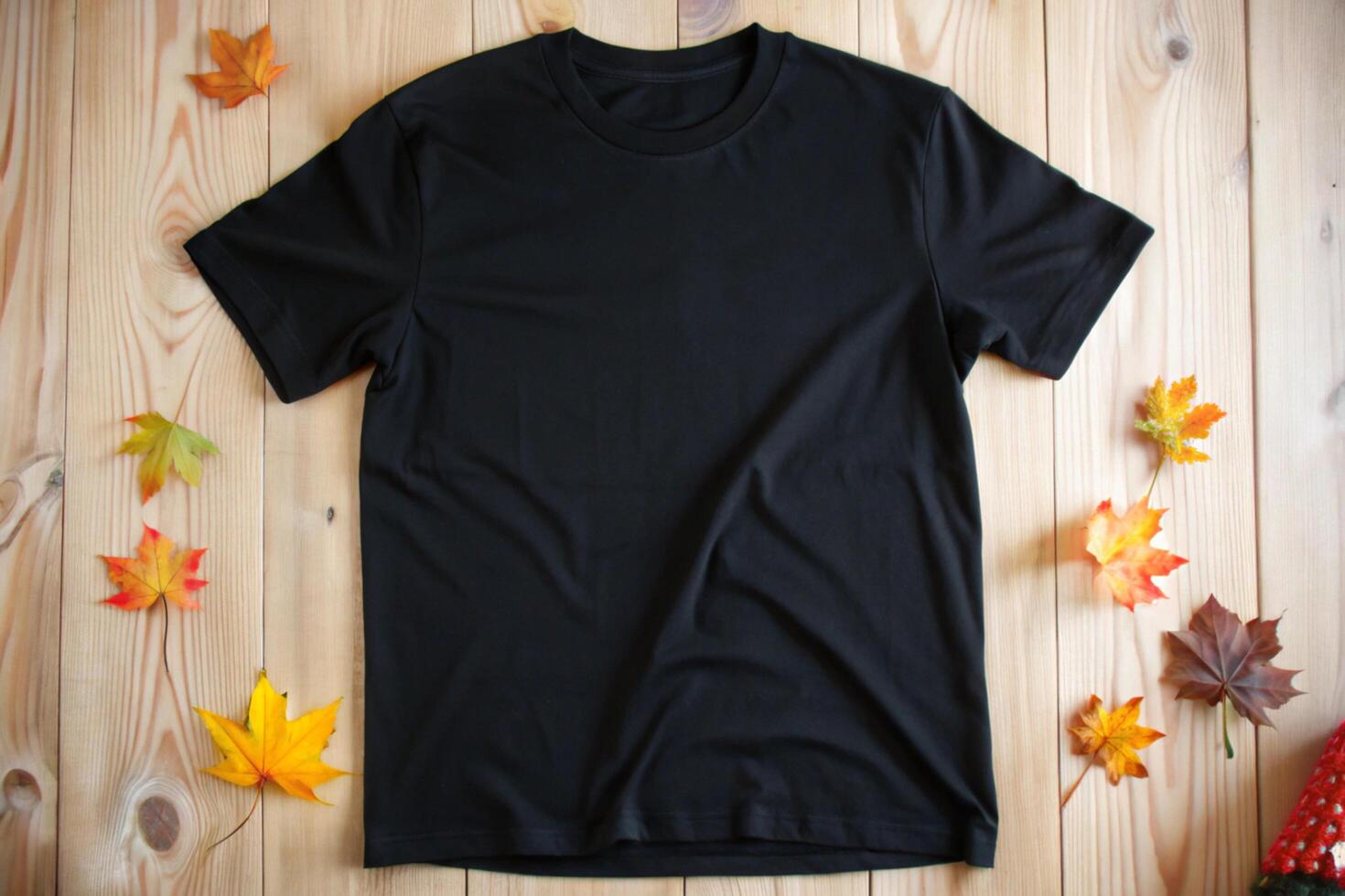 Black t - shirt on wooden background with autumn leaves photo
