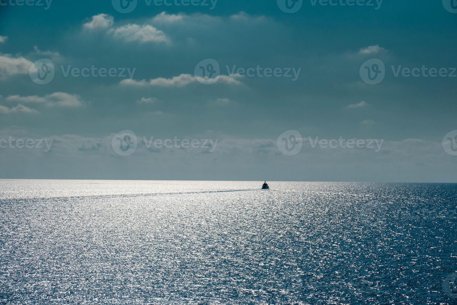 boat in the middle of the sea sails alone among the waves to the horizon on a late summer day in 2024 photo
