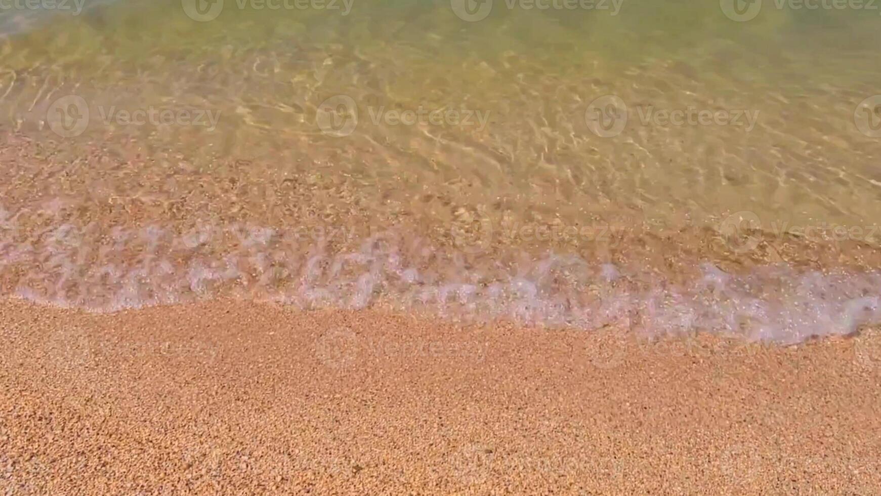 Serene beach and gentle, calm waves, yellow sand on a sunny day. Sandy beach, shore, close up top view. photo