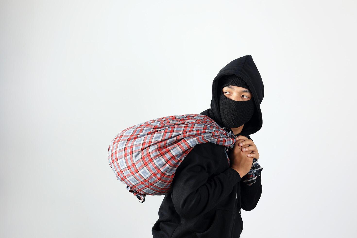 Thief with Sarung Bag Looking at Side, Feeling Satisfied After Robbery photo